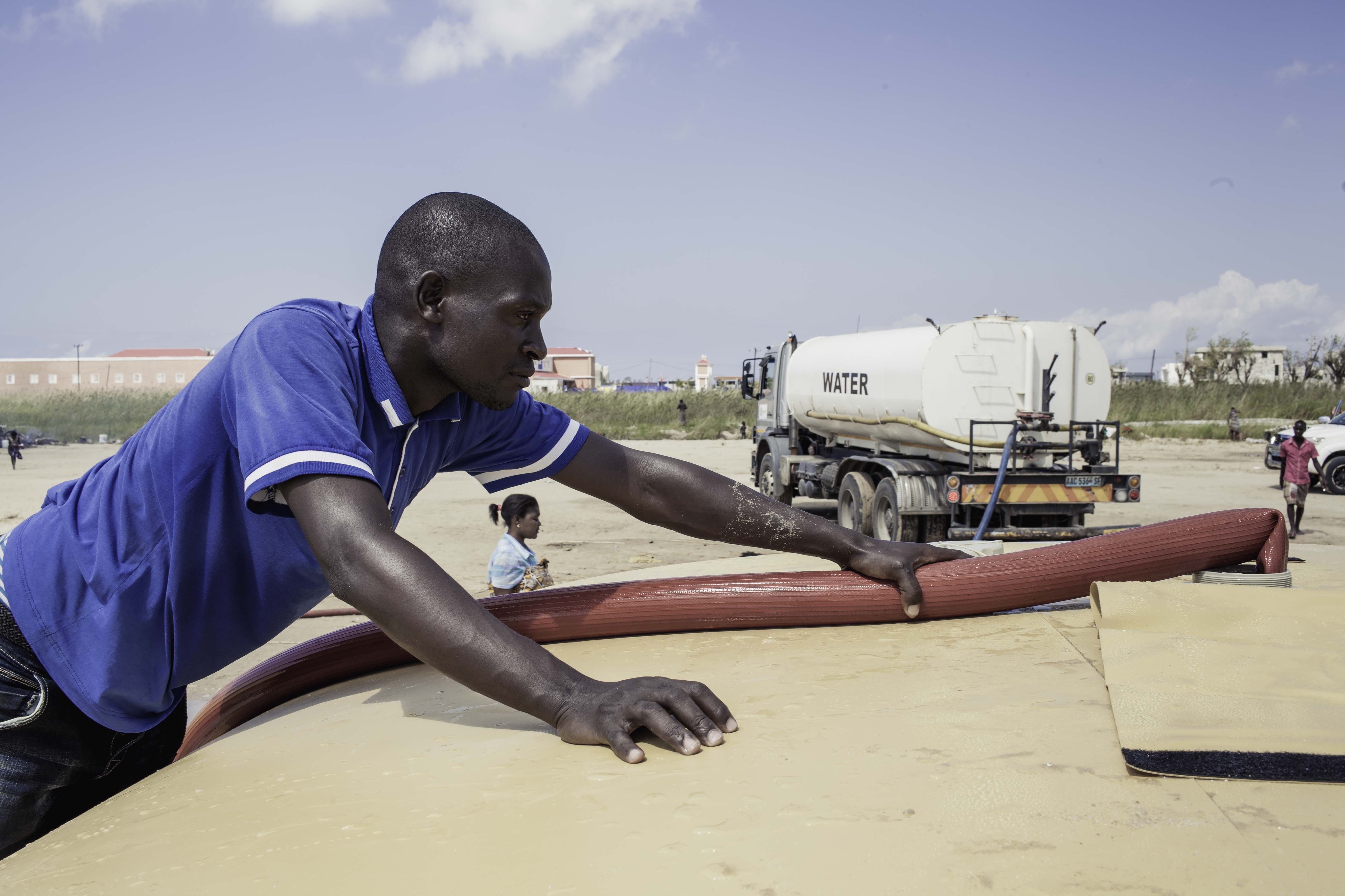 Watertrucker Miosés Domingos (Wateraid) is filling the bladders that Oxfam contributed and elevated. The bladders can contain 10,000 litres of water and were refilled twice a day, which were enough to provide 2,000 families with their emergency water needs. (Photo: Micas Mondlane / Oxfam Novib)